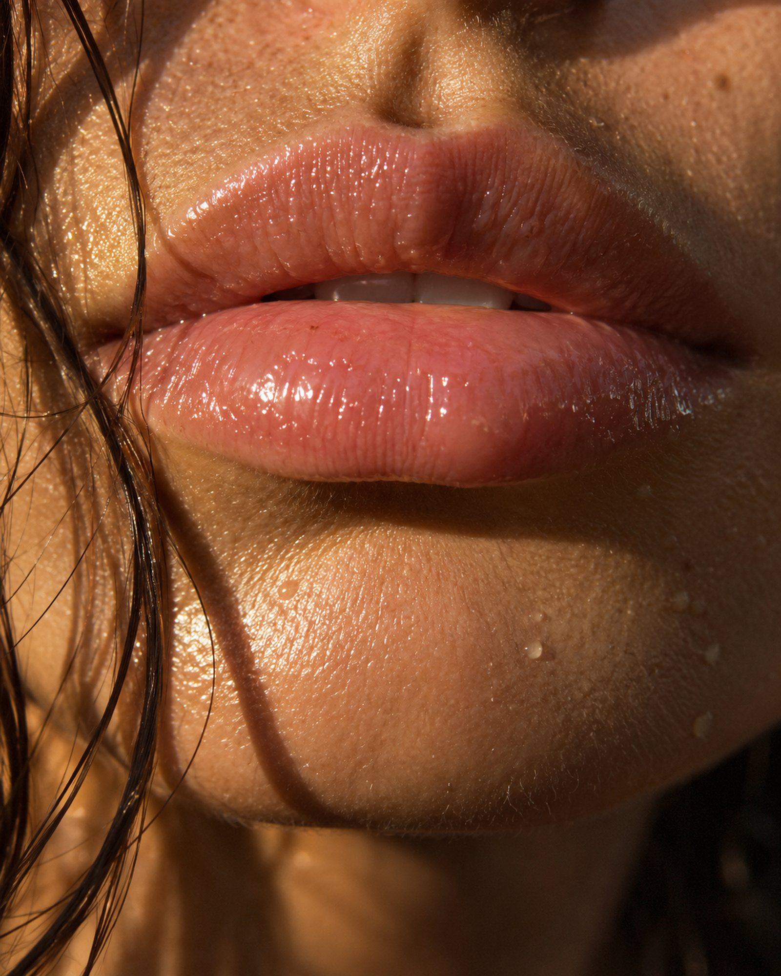 Bare, glossy lips in golden light